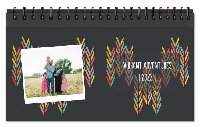 black patterned spiral bound desk calendar printed with a photo and &quot;vibrant adventures 2023&quot;