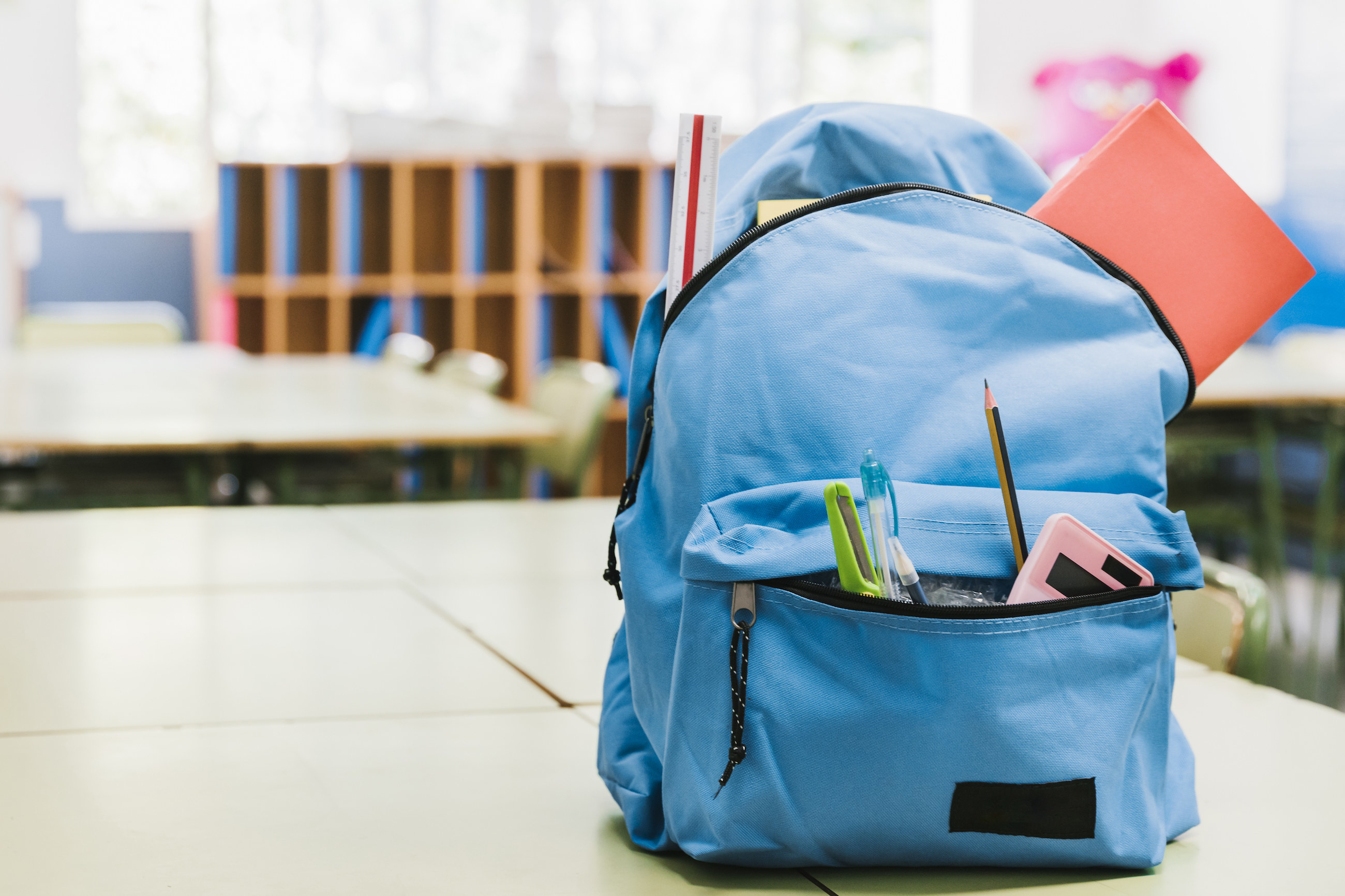 Closeup of a blue backpack with items sticking out of the pockets