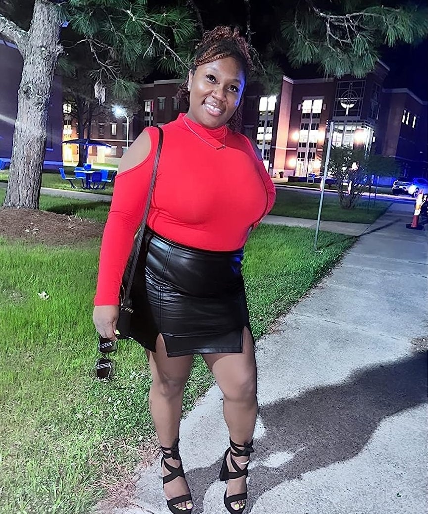 reviewer in black skirt with heels and red top