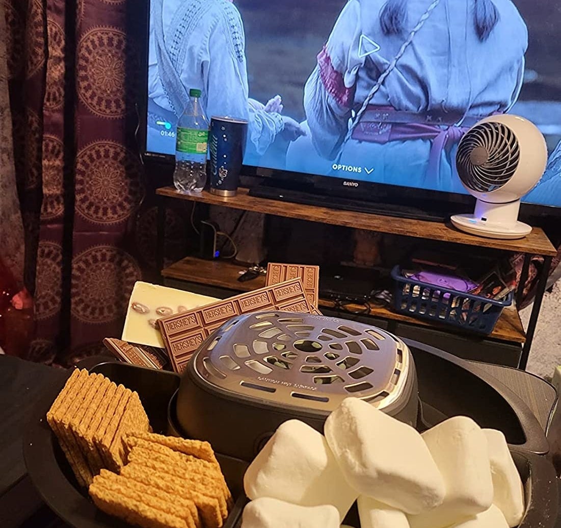 A reviewer&#x27;s photo of them using the s&#x27;mores maker