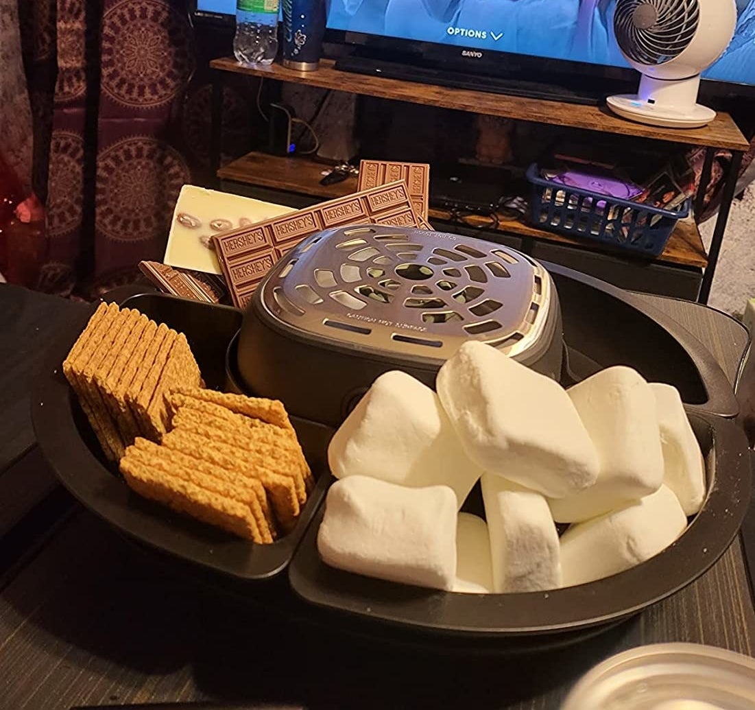 A reviewer&#x27;s photo of them using the s&#x27;mores maker