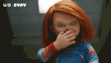 Chucky the red-headed, evil doll is kissing and waving goodbye