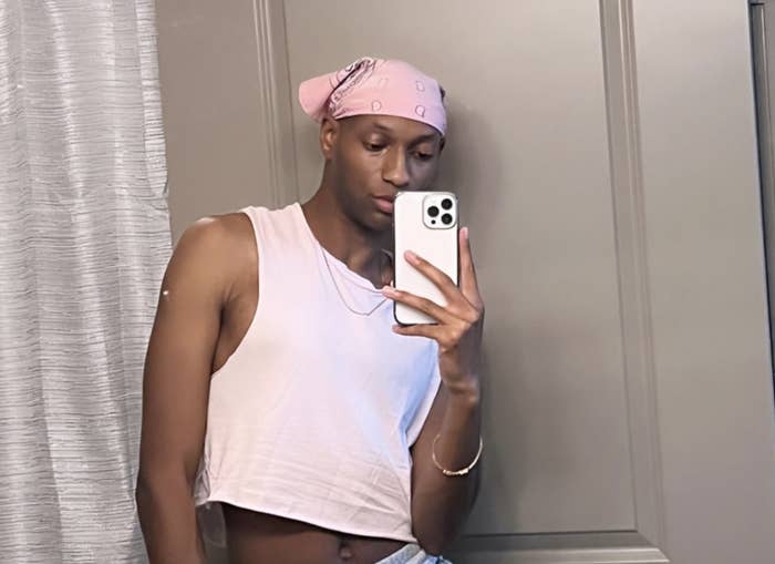 Jae takes a mirror selfie wearing a crop top and a bandana