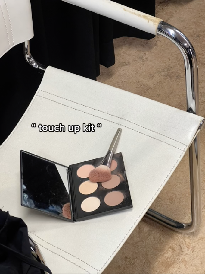 A close-up of the touch-up kit which has six powders of various light shades on a chair