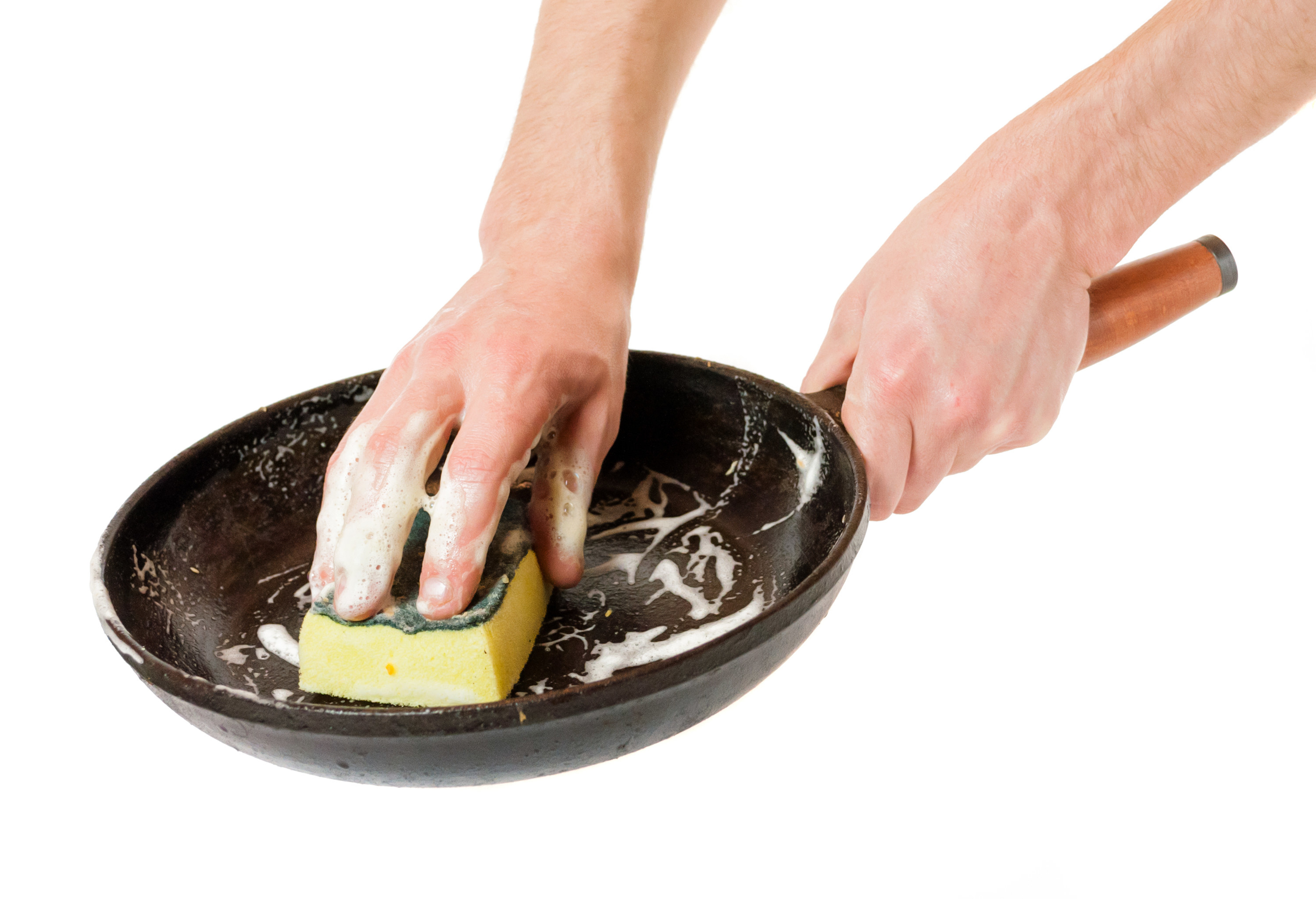 A person scrubbing and washing a pan