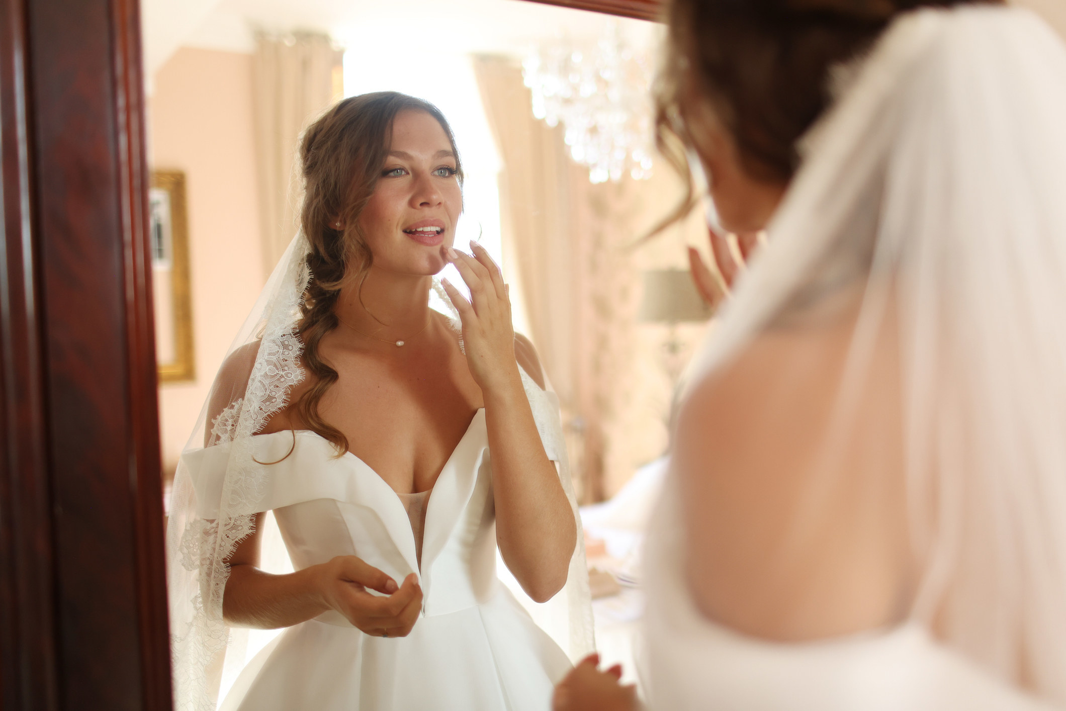 A bride looks in the mirror and fixes her lipstick