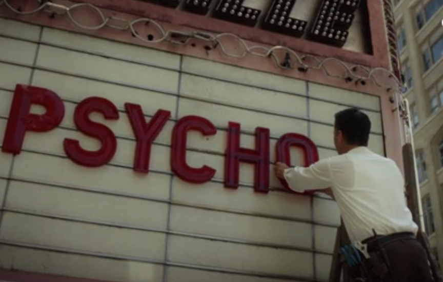 A man putting movie letters on a marquee, spelling &quot;PSYCHO&quot;