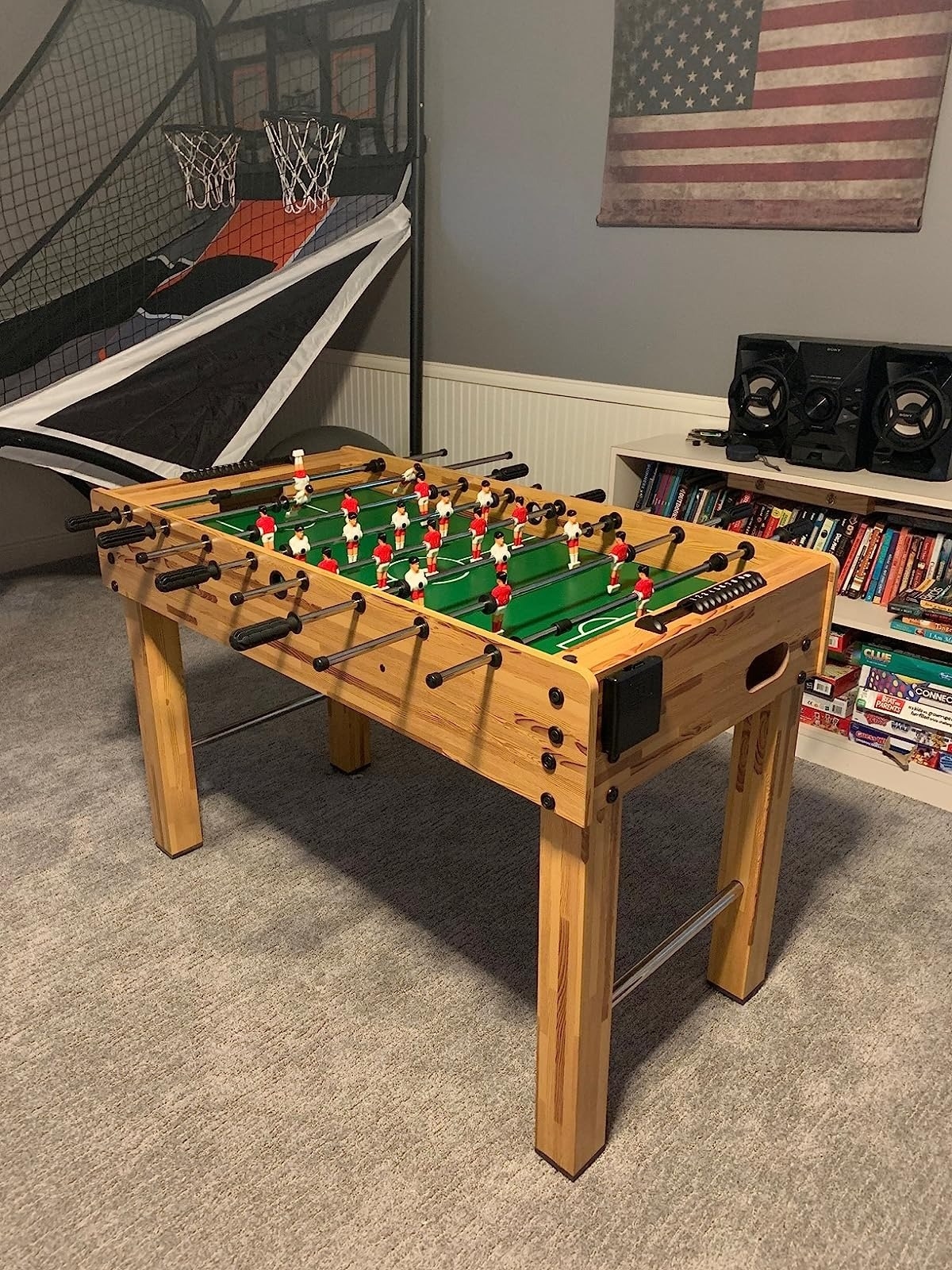 the wood foosball table on carpet in game room