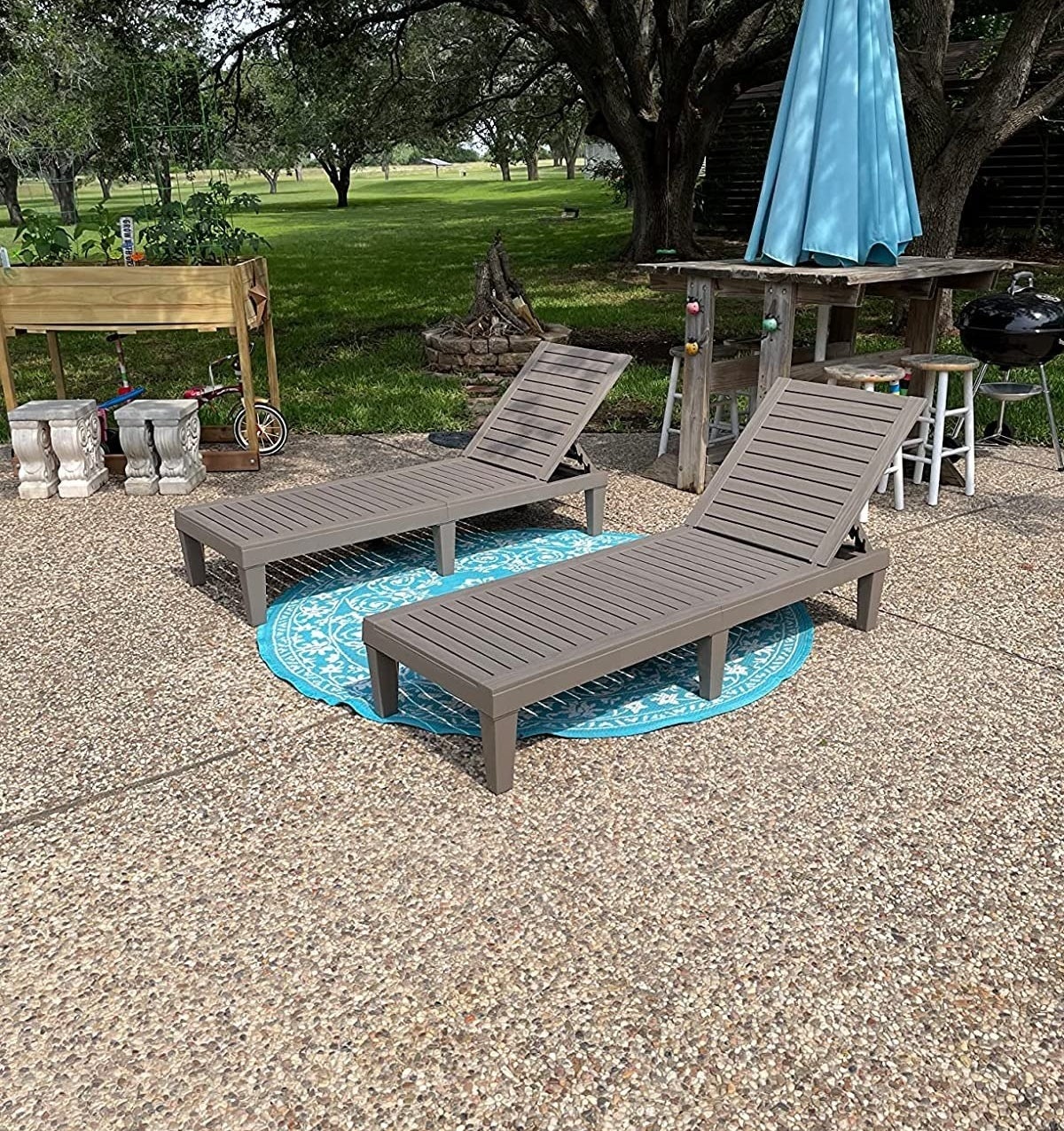 gray chaise chairs next to blue umbrella