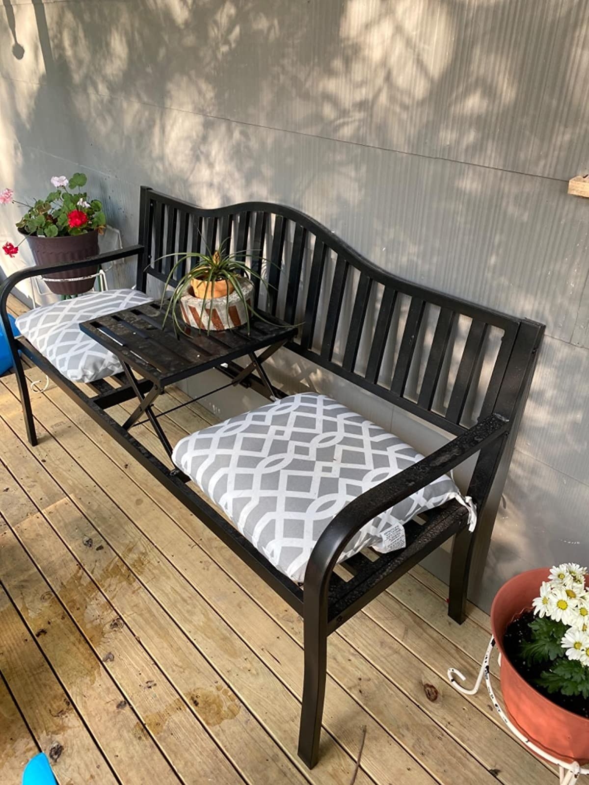 the outdoor bench with gray and white patterned cushions