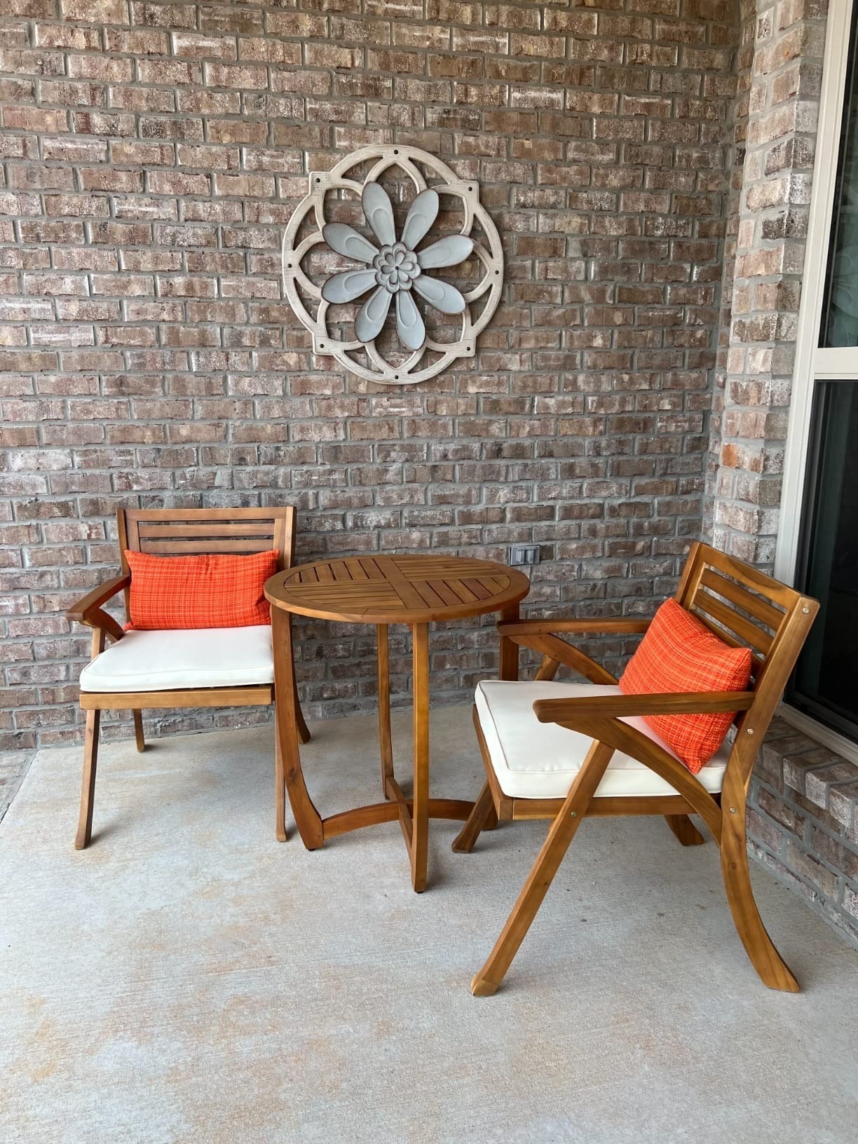 orange throw pillows on top of brown patio chairs outside