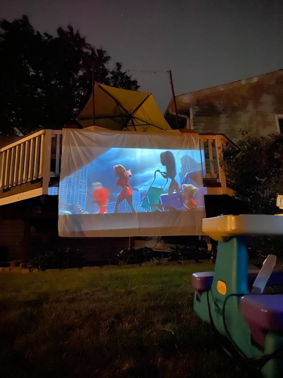 the projector attached to an outdoor pool railing at night