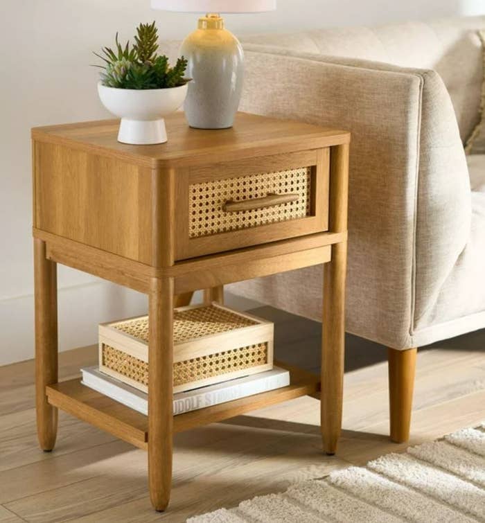 light wooden night stand with handle next to couch
