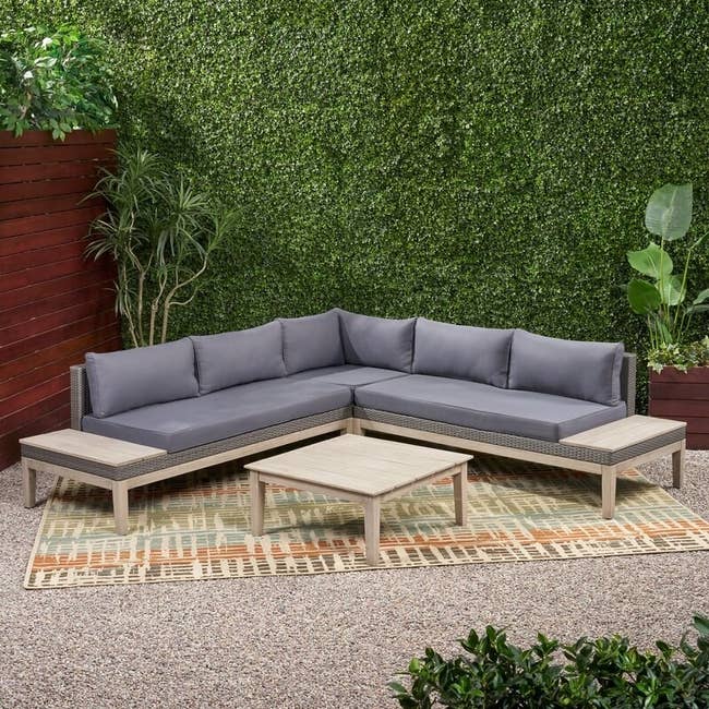 wood sectional sofa with gray cushions and pillows on a patio