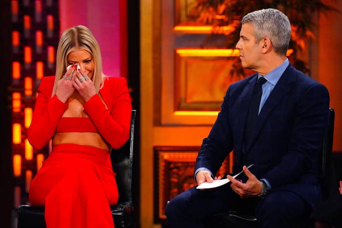 Ariana Madix crying and wiping her eyes as Andy Cohen looks on