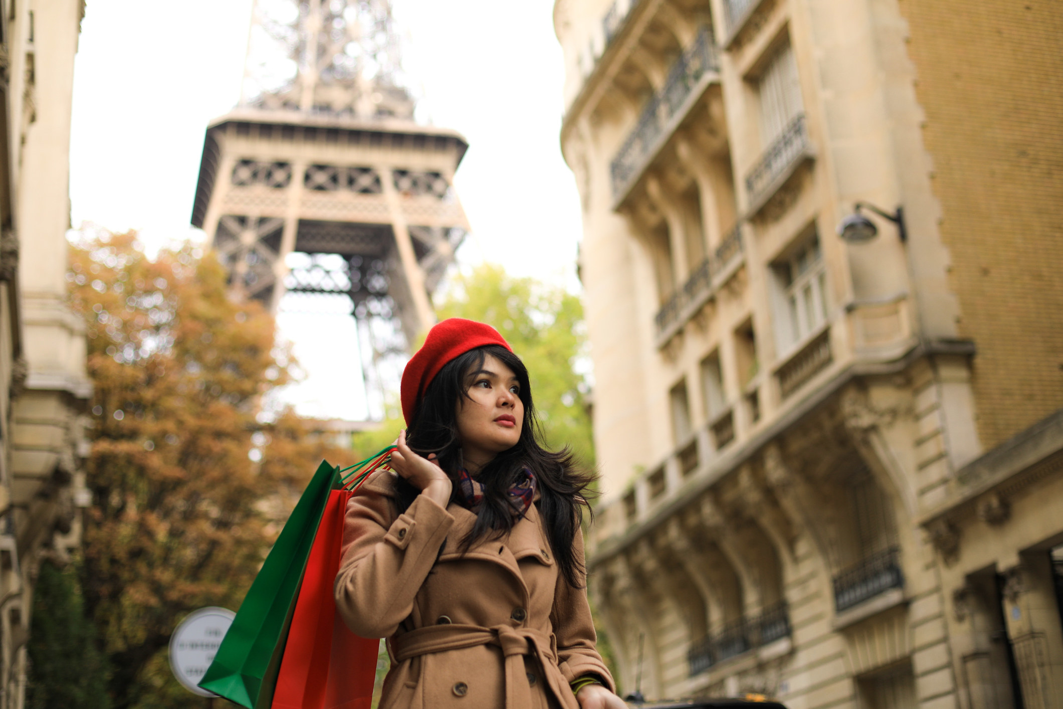 A young woman in Paris holding shopping bags