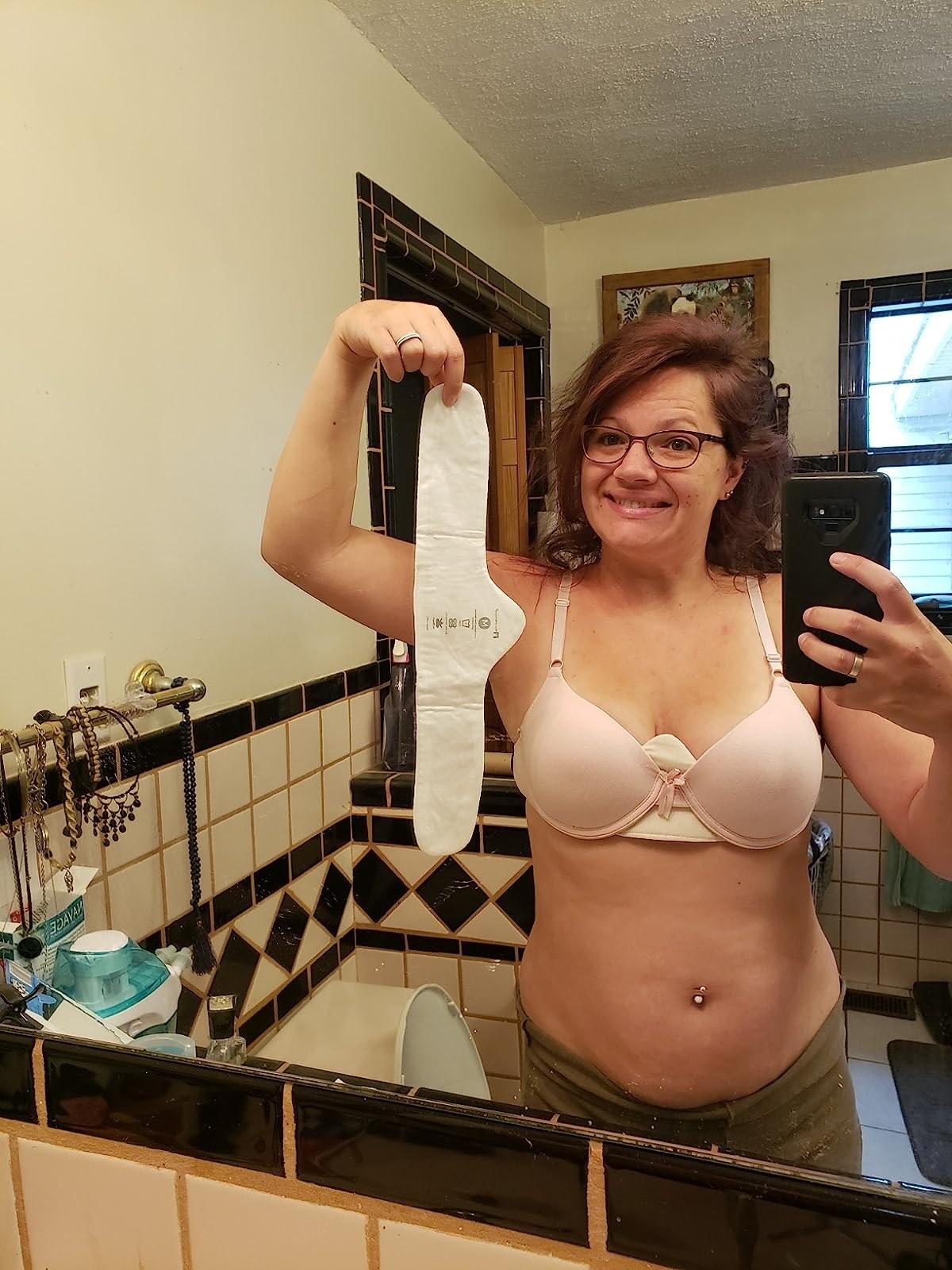 Reviewer with liner under bra and holding up another white liner in hand