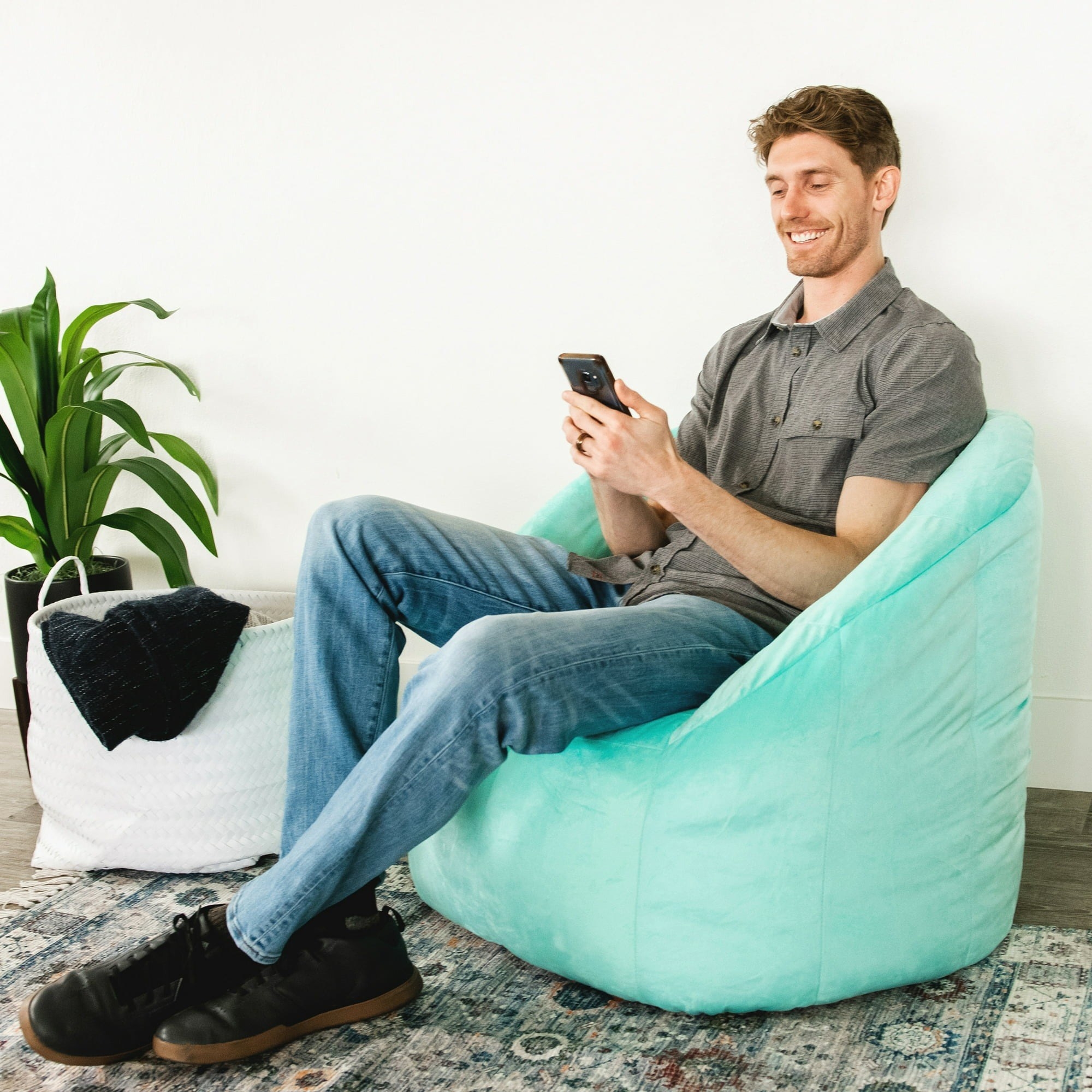 model sitting in light blue bean bag chair
