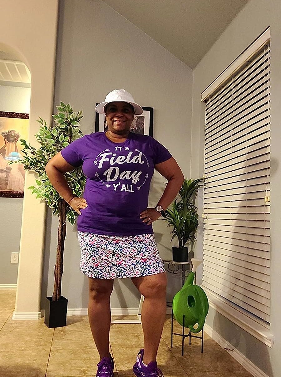 A reviewer wearing a patterned skort with a purple top