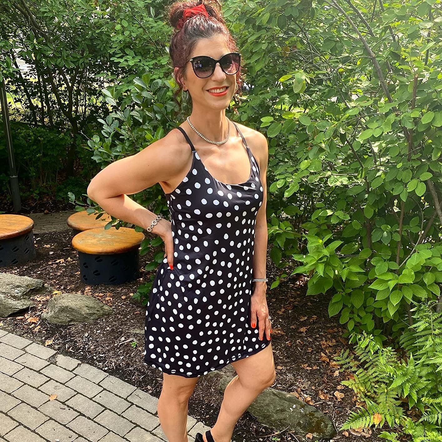 A reviewer wearing a black and white polka-dot dress