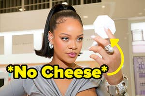 Rihanna looking at the mirror of a highlighter pallet. 