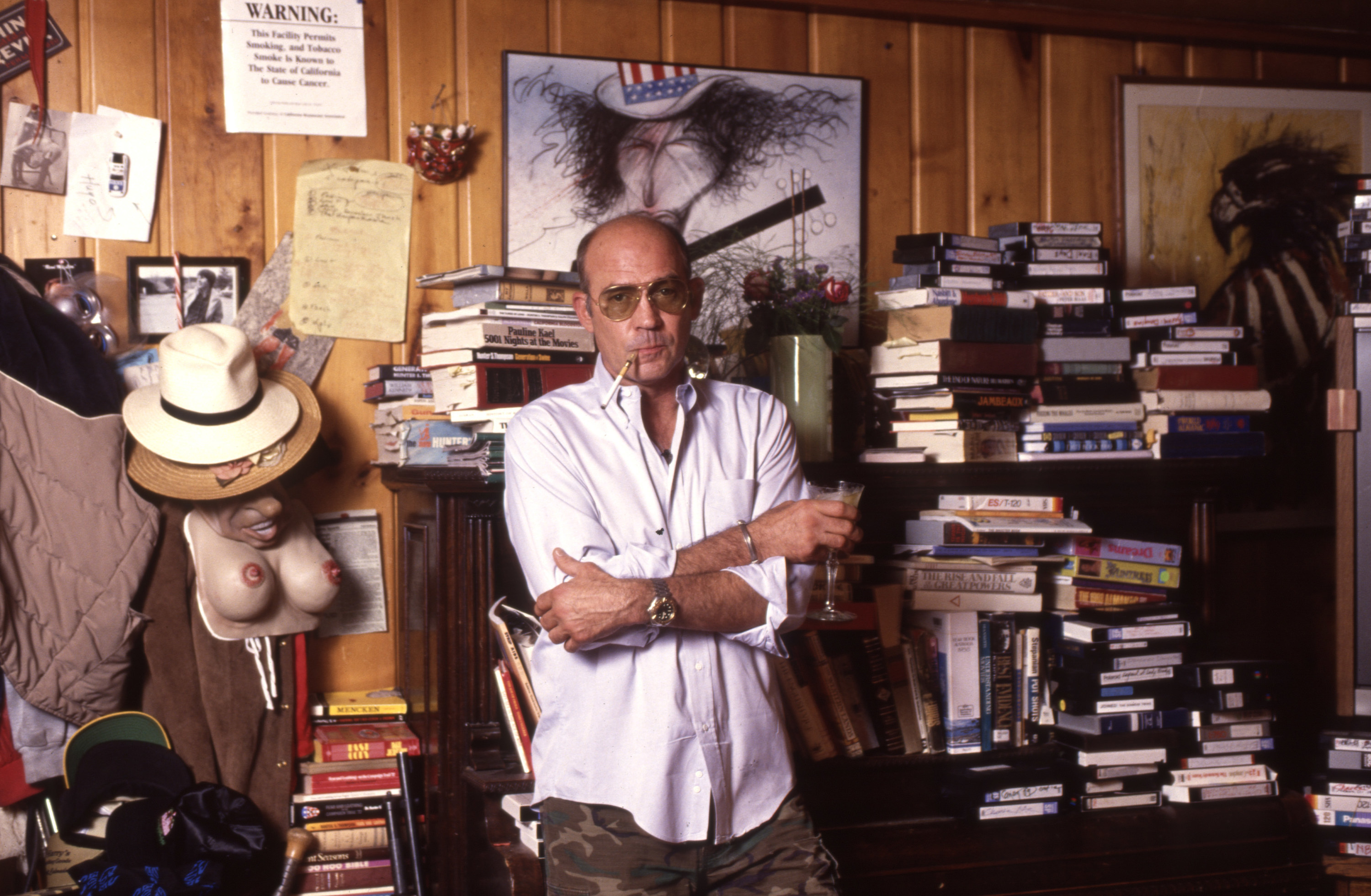 Hunter Thompson at his ranch against a bookcase