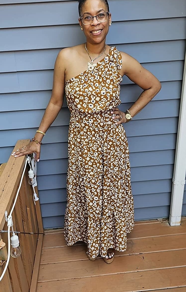 Reviewer wearing one shoulder dress in brown and white leopard print