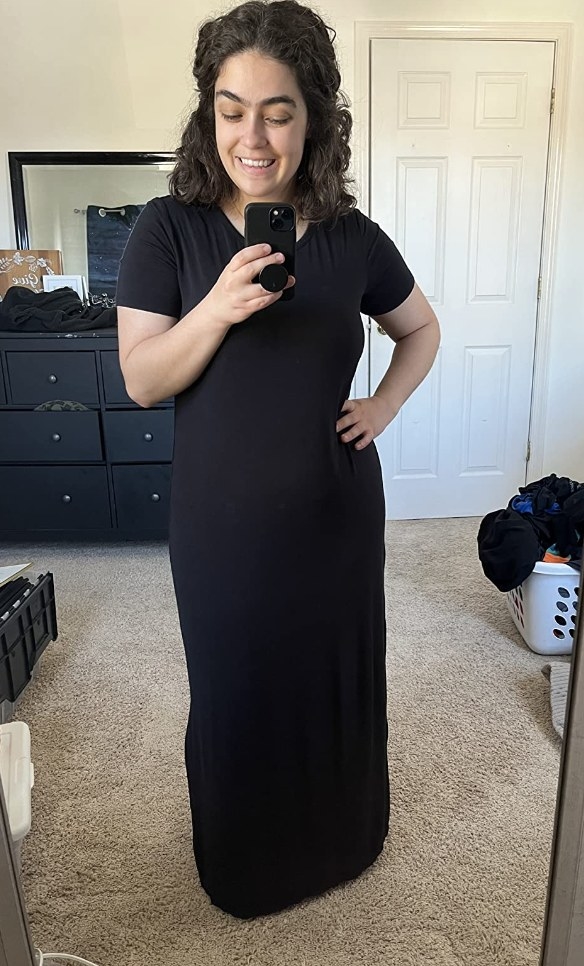 A reviewer wearing a black maxi dress