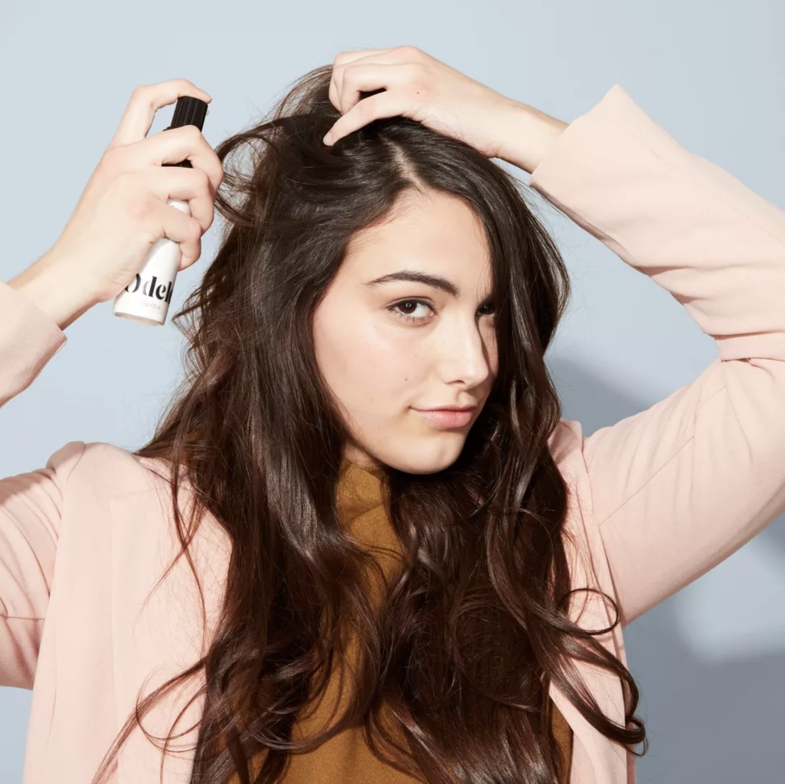 model using dry shampoo on her hair