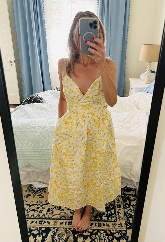 A reviewer wearing a yellow floral dress