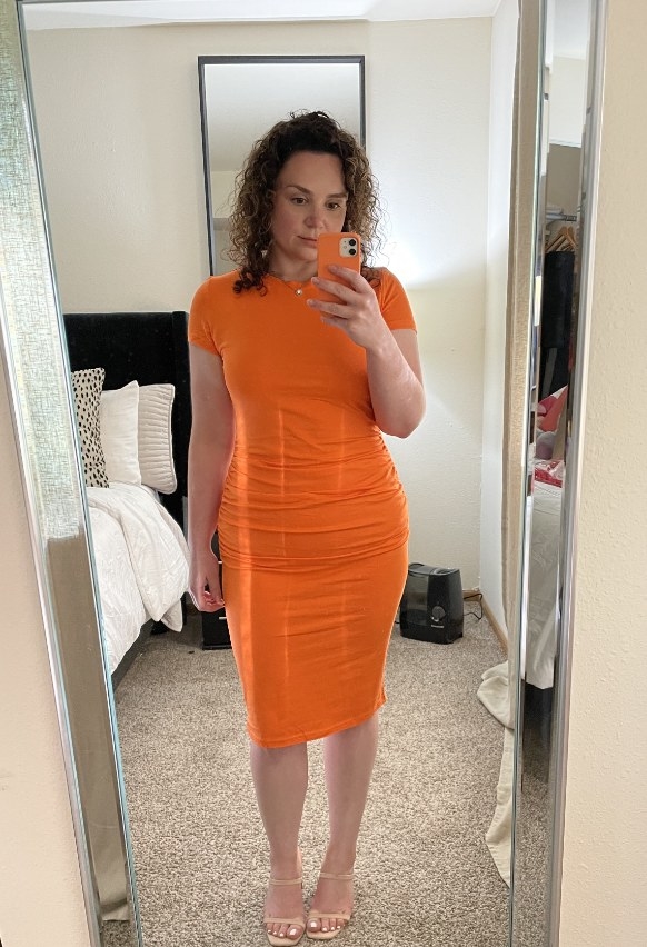 A reviewer wearing an orange dress