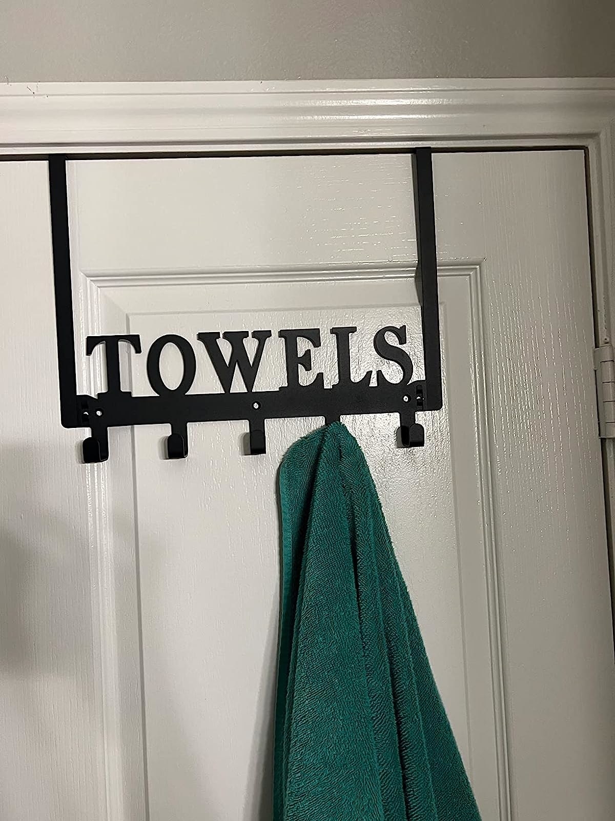 Reviewer image showing a towel hanging on the &quot;Towels&quot; hanger on their door