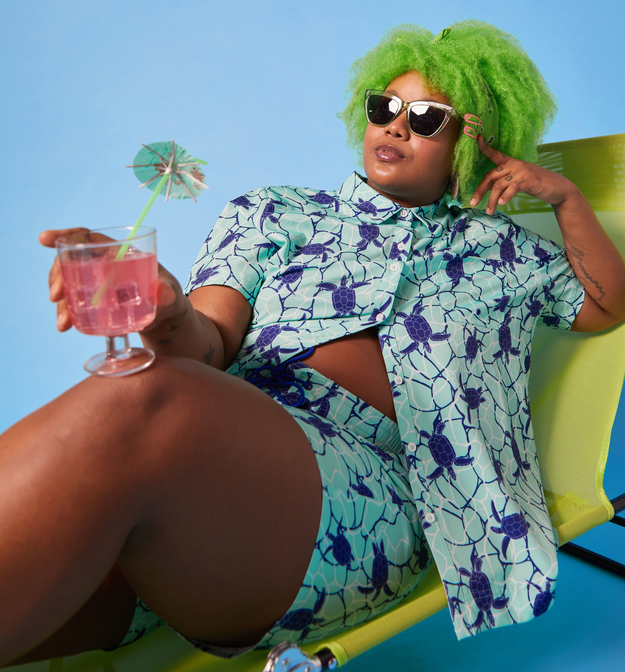 plus size model wearing the shirt and shorts while sitting on a beach chair