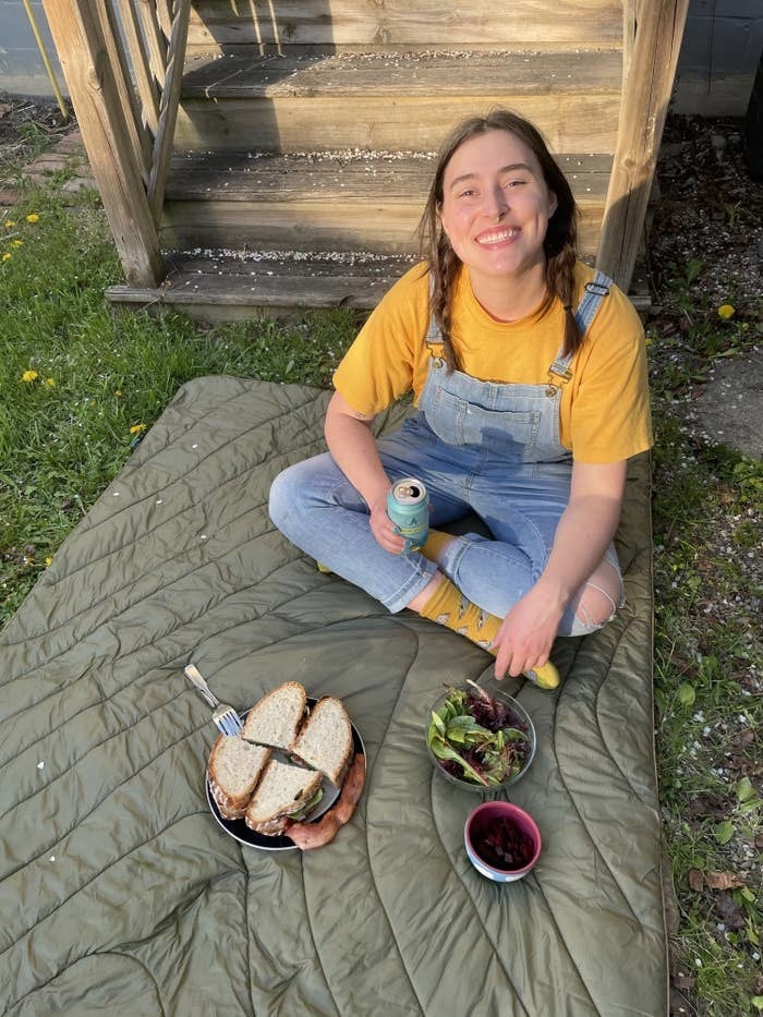 writer picnicing on olive green rumpl blanket