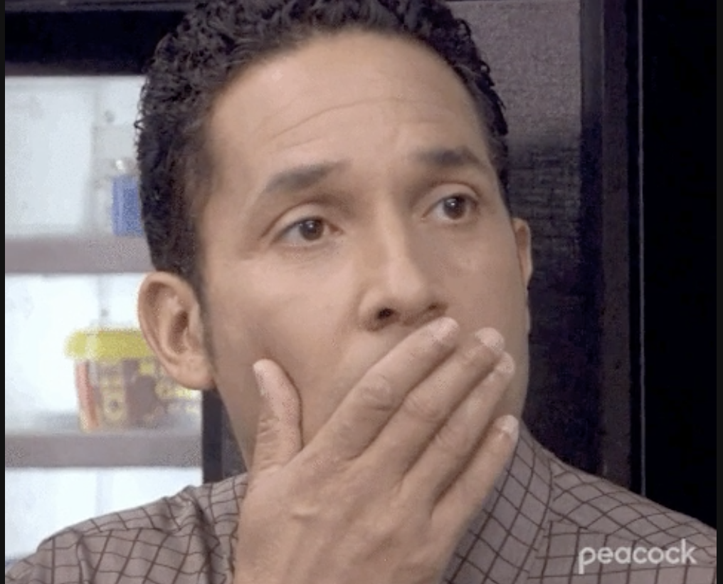 a person looking shocked with his hand to his mouth