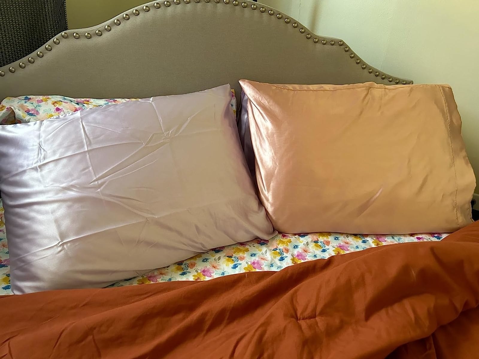 a reviewer&#x27;s photo of the satin pillowcases on their bed