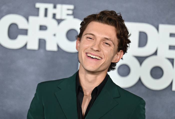 Tom smiles widely on the red carpet for The Crowded Room