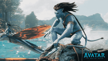 A member of the Na&#x27; vi riding a creature in the water in Avatar: The Way of Water