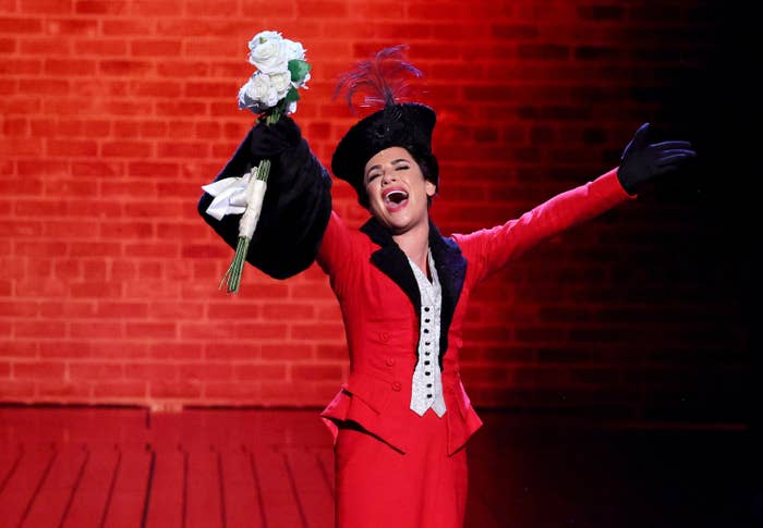 Lea Michele holding a bouquet of flowers and performing on stage as Fanny Brice at the Tony Awards