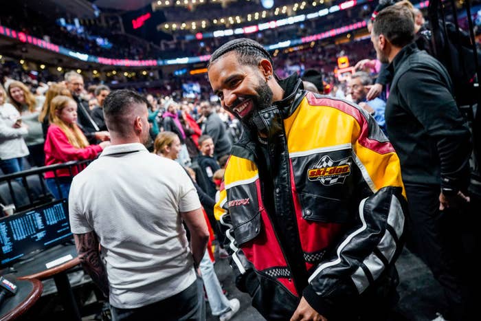 Drake smiles and walks off the court after the game between the LA Clippers and the Toronto Raptors on December 27, 2022 at the Scotiabank Arena in Toronto, Ontario, Canada