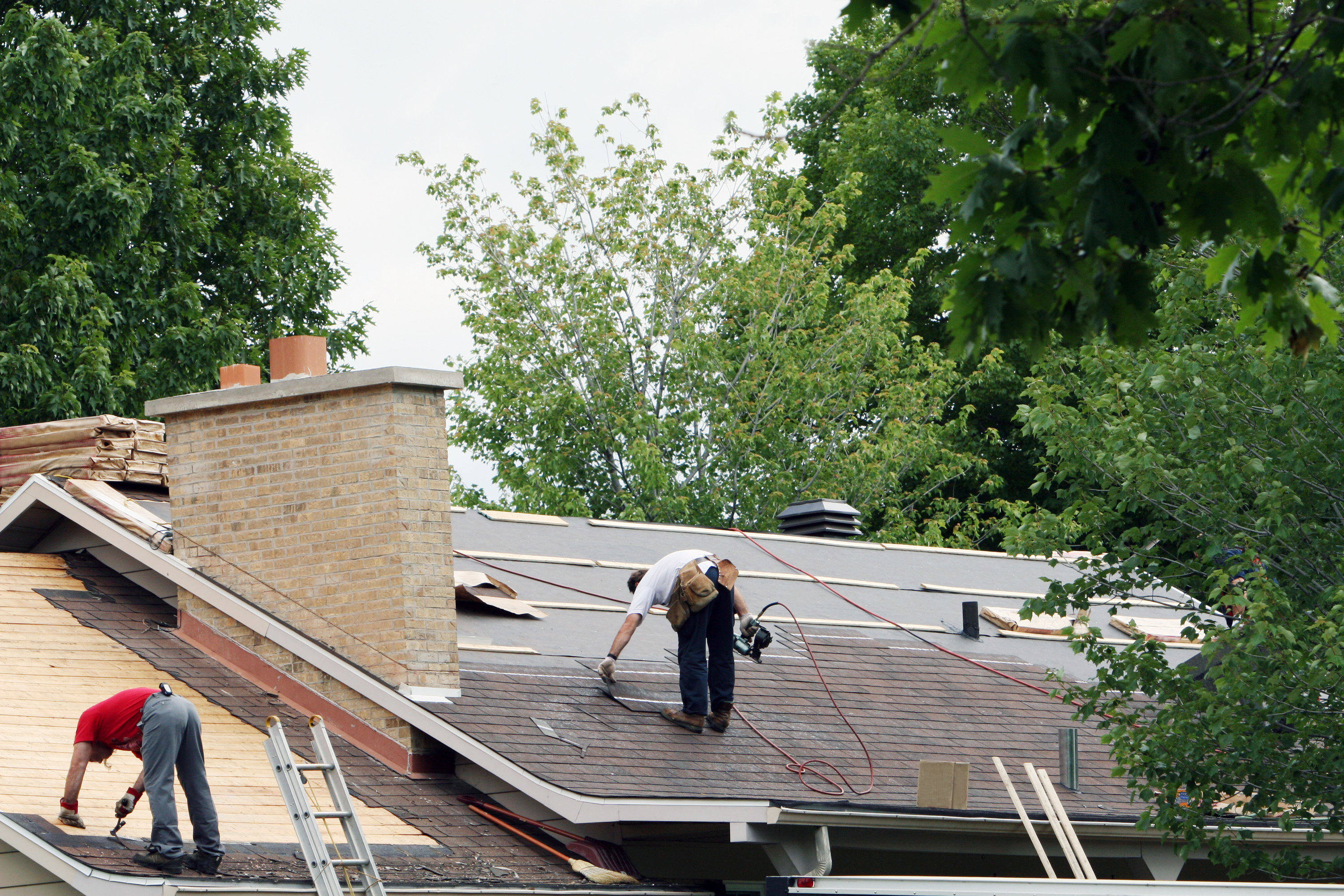 people repairing a large roof