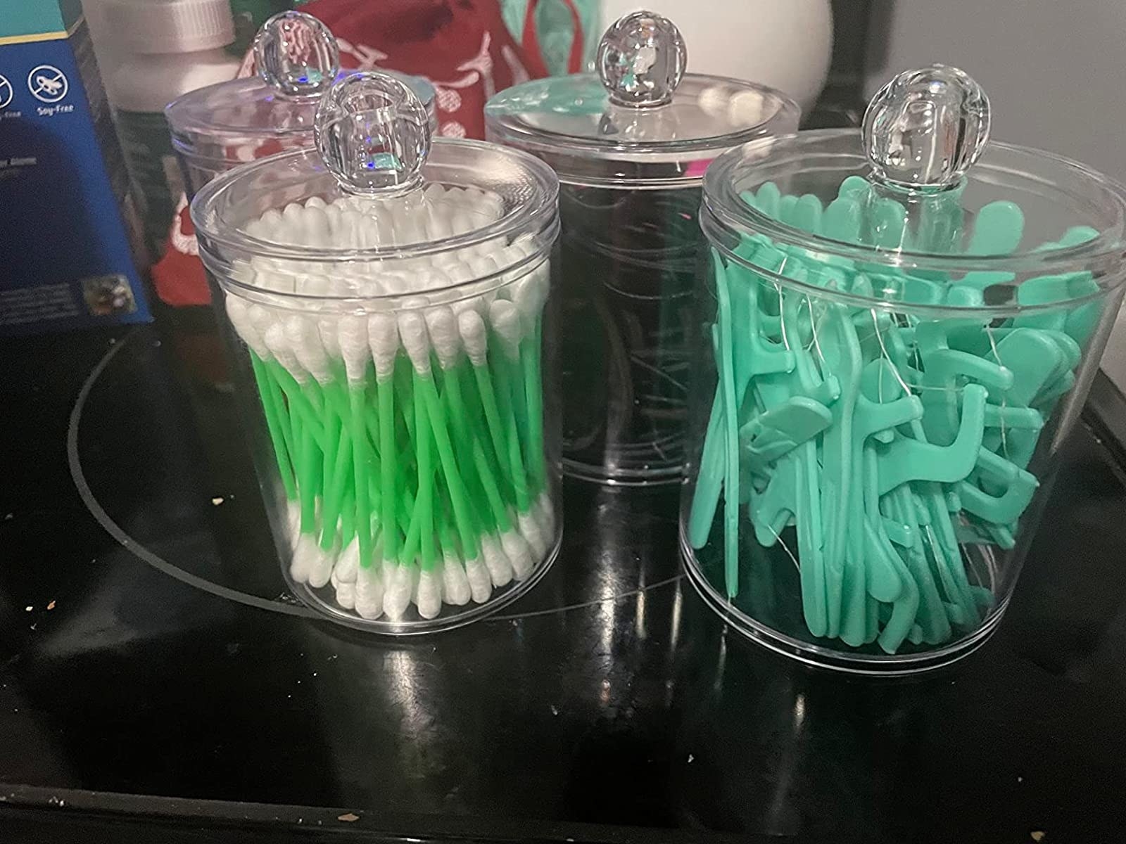 a reviewer&#x27;s photo of the jars holding Q-tips, floss picks and hair ties