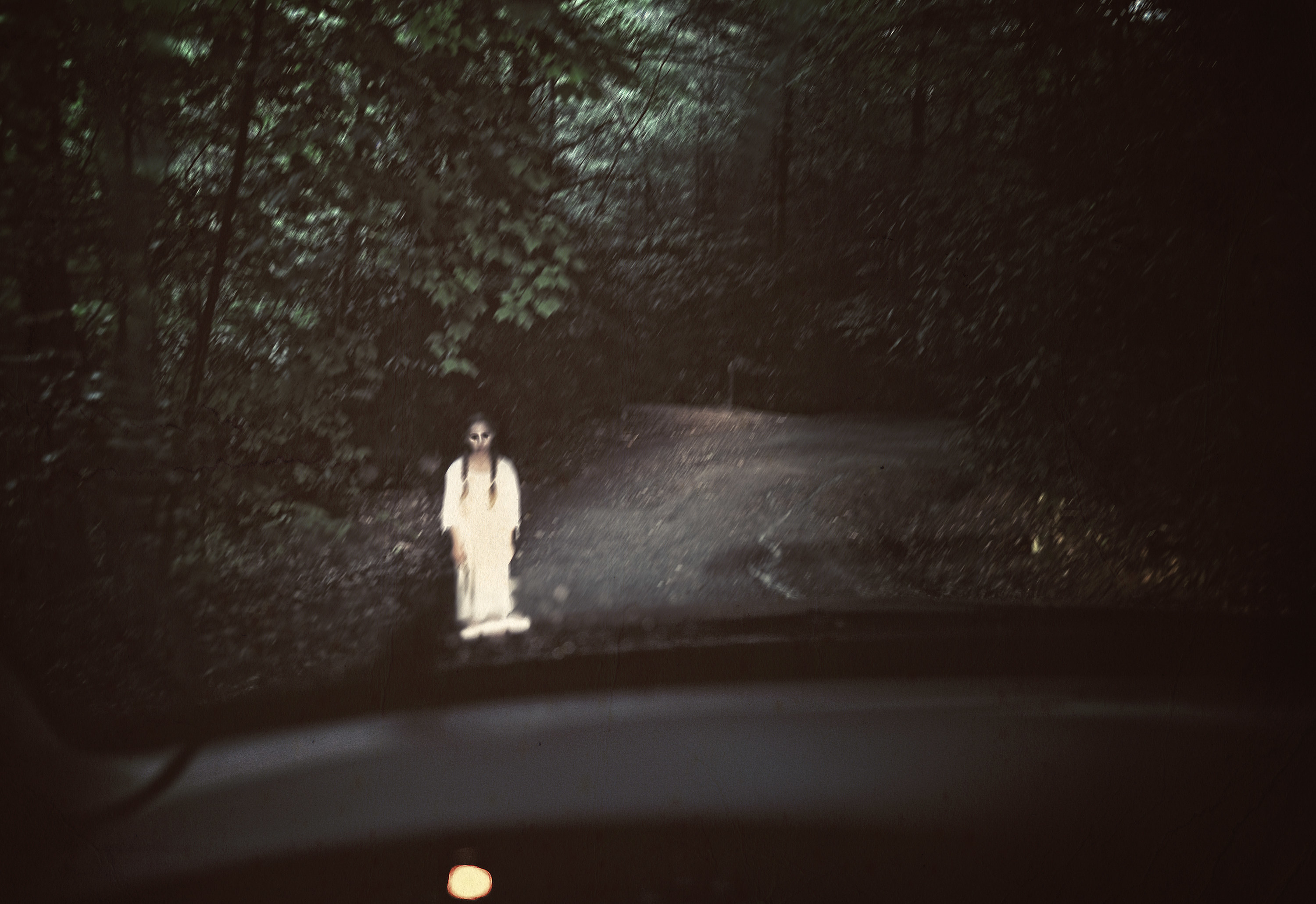 a little girl stands in the middle of the road