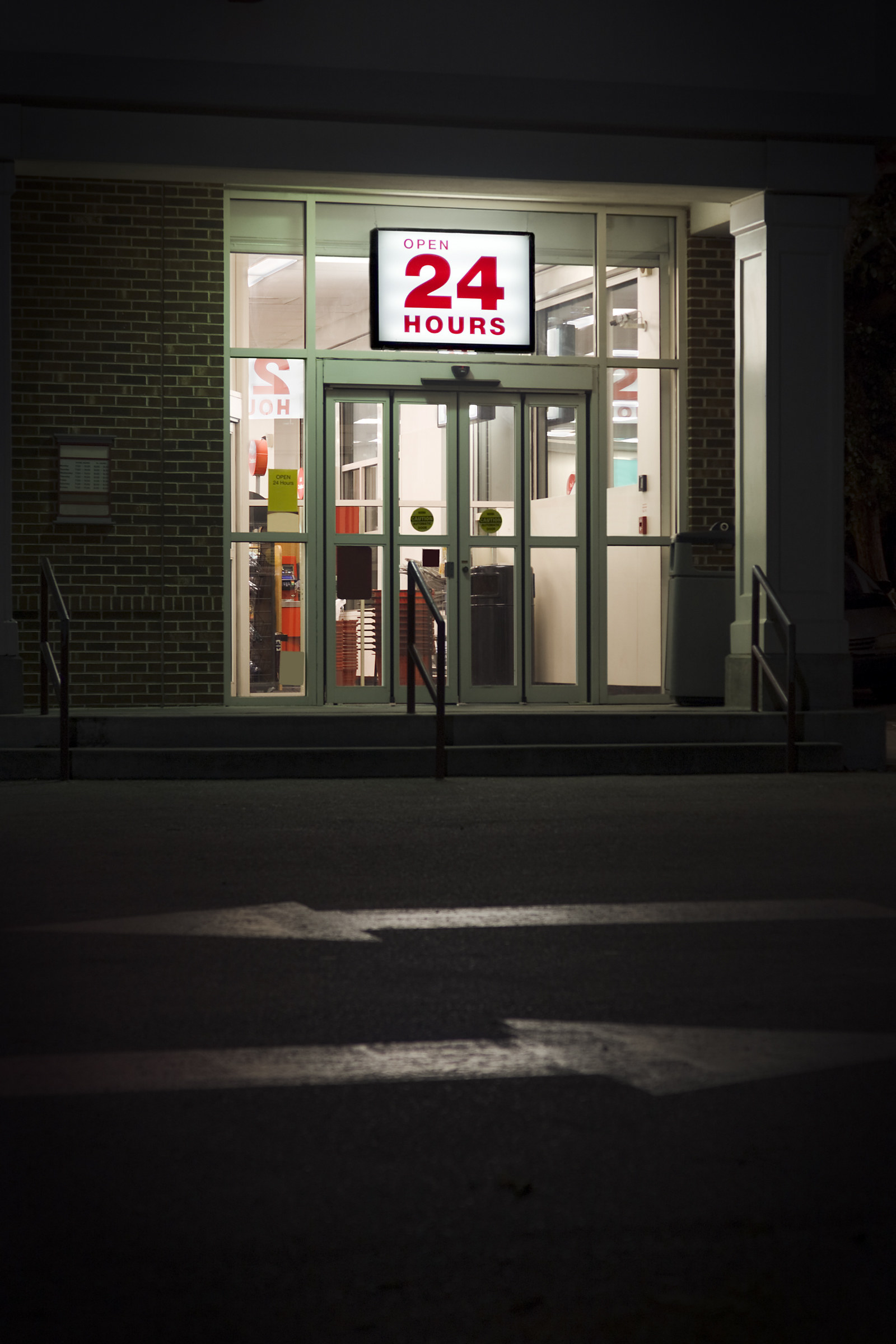 A store with a lit up 24-hour sign.