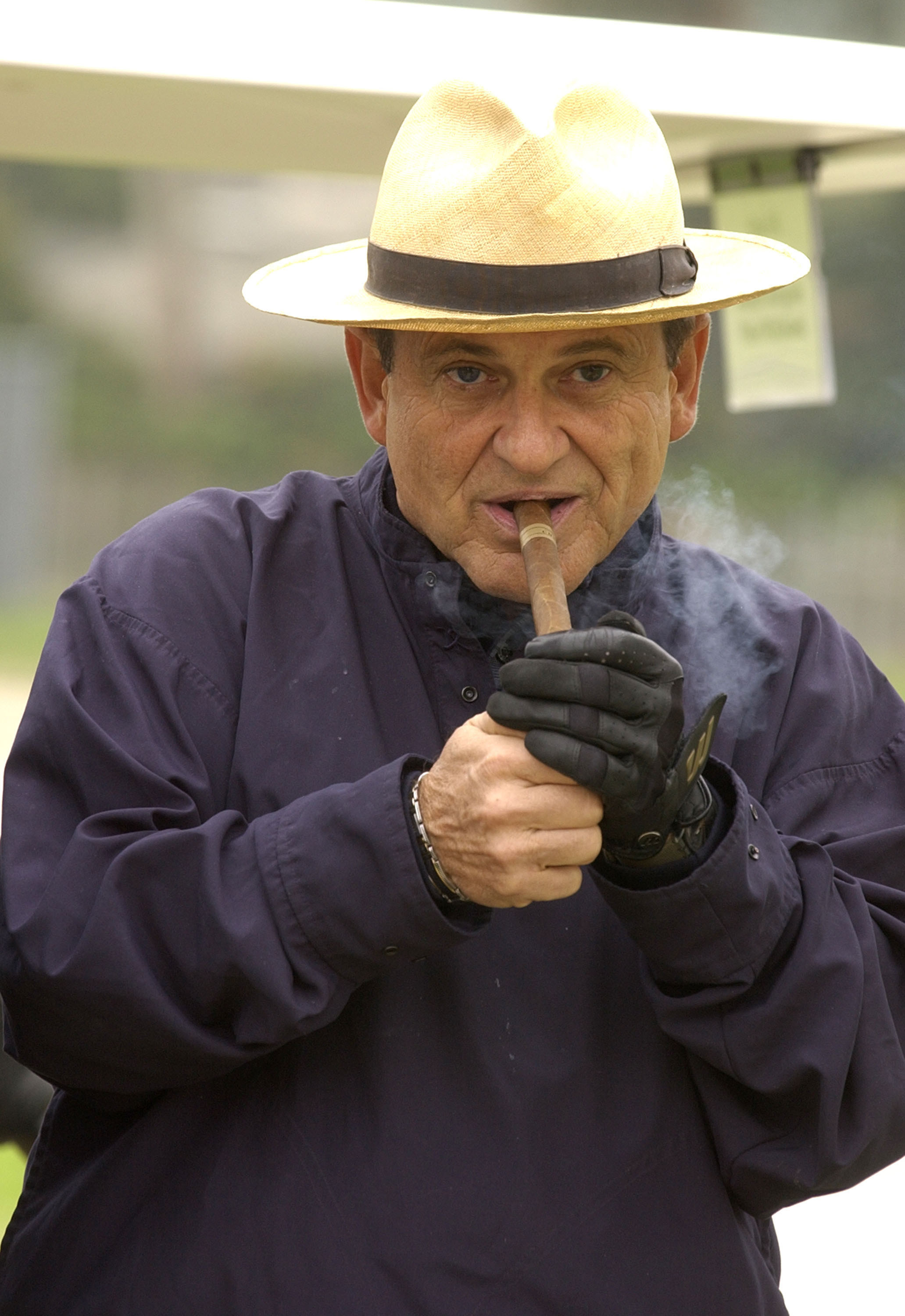 Joe Pesci lighting and smoking a cigar