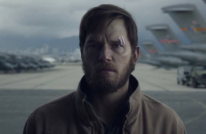 A close-up of Chris Pratt, who a bandage over his eyebrow, stands in a plane hangar in a scene from &quot;The Terminal List&quot;