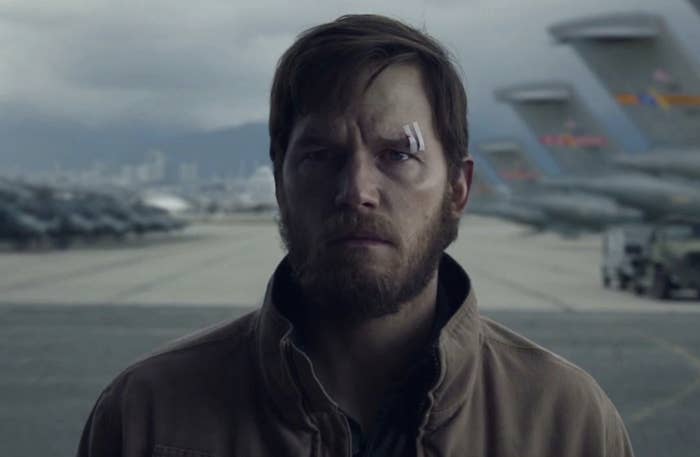 A close-up of Chris Pratt, who a bandage over his eyebrow, stands in a plane hangar in a scene from "The Terminal List"
