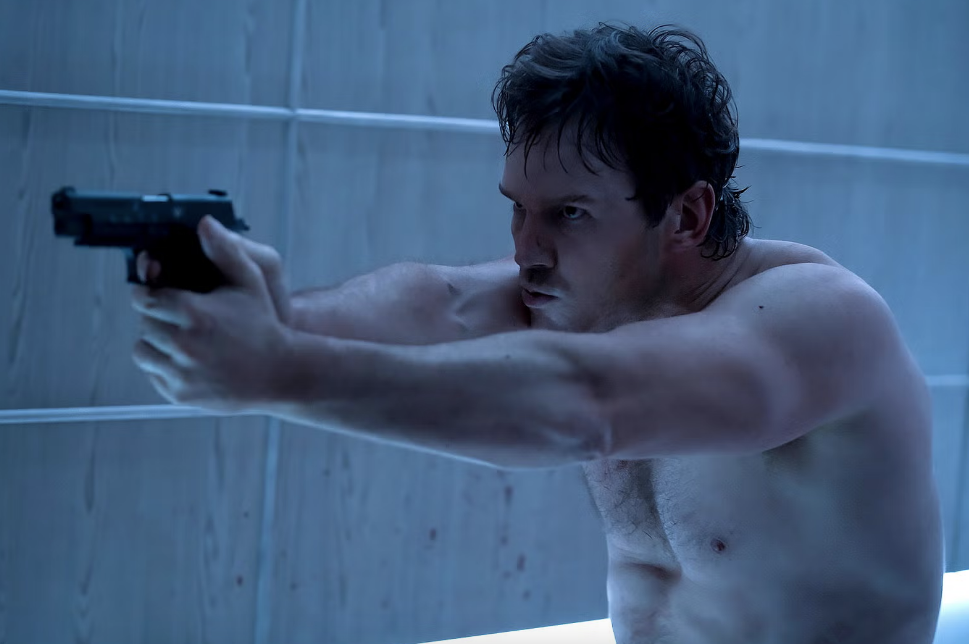A shirtless Chris sitting up and pointing a gun in a scene from &quot;The Terminal List&quot;
