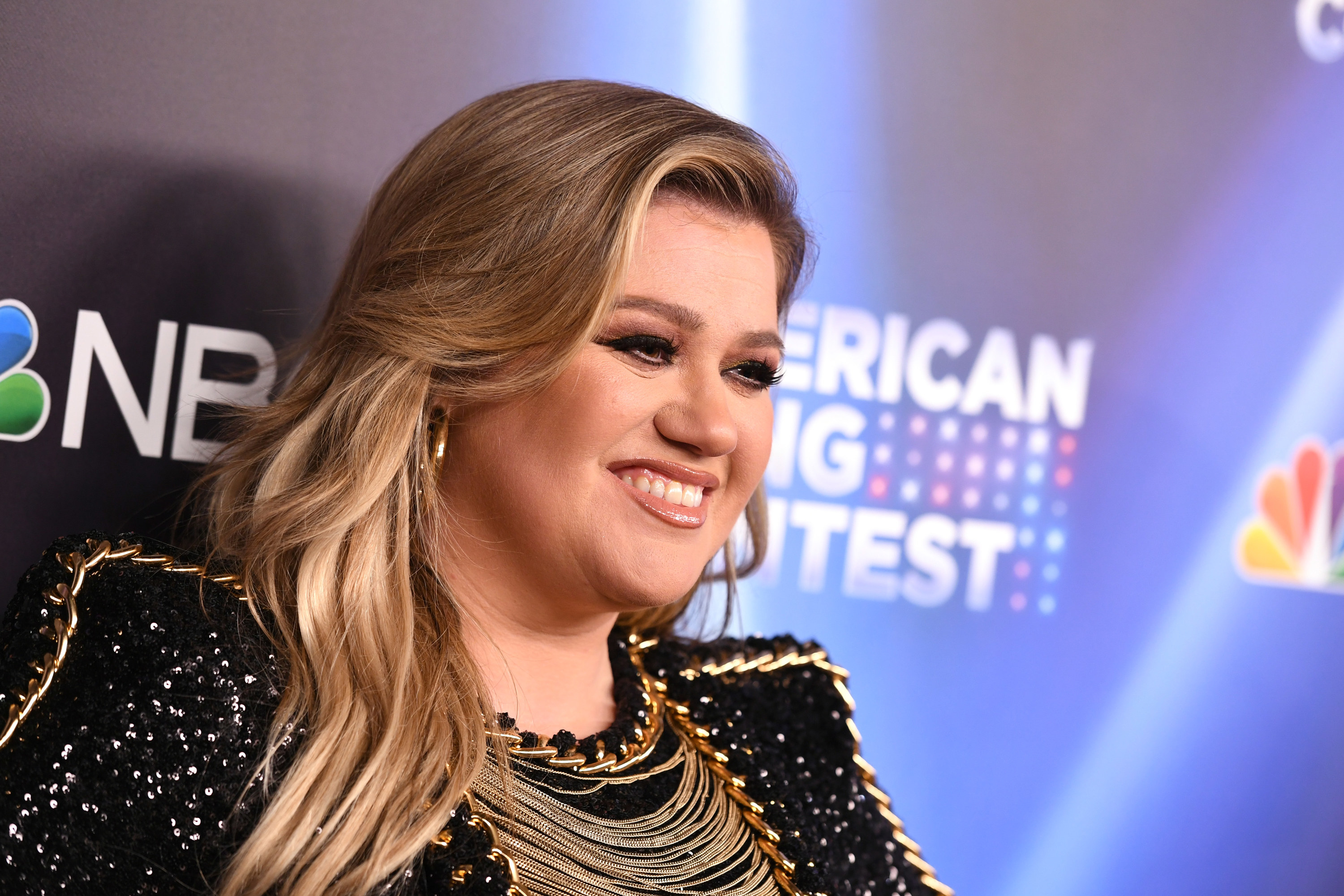 Close-up of Kelly smiling and wearing a sparkly outfit