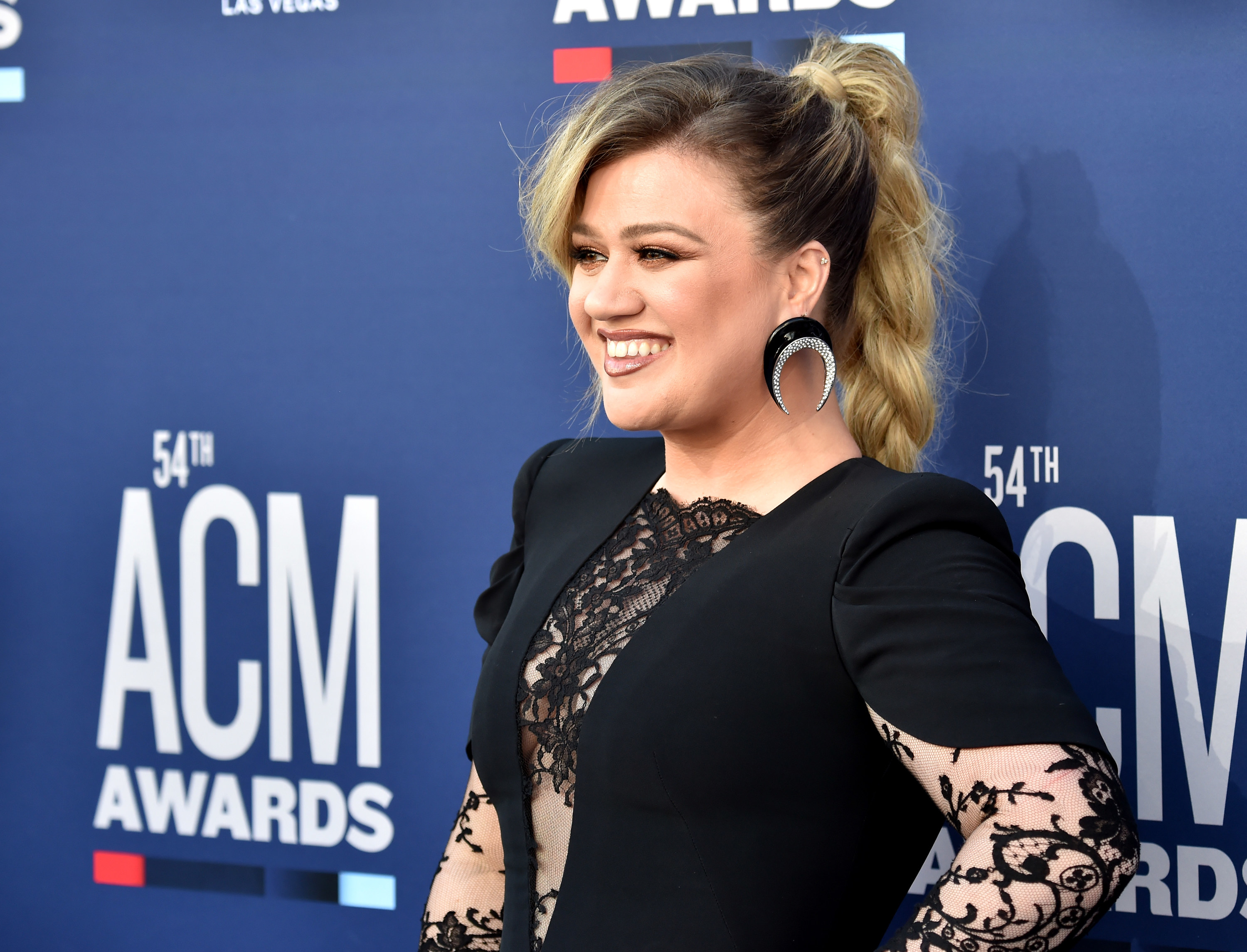 Close-up of Kelly smiling and wearing a lacy outfit